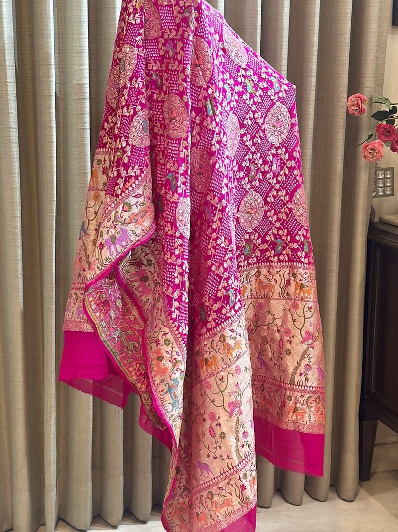 A magenta brocade dupatta worked with gold zari and a deep pink border