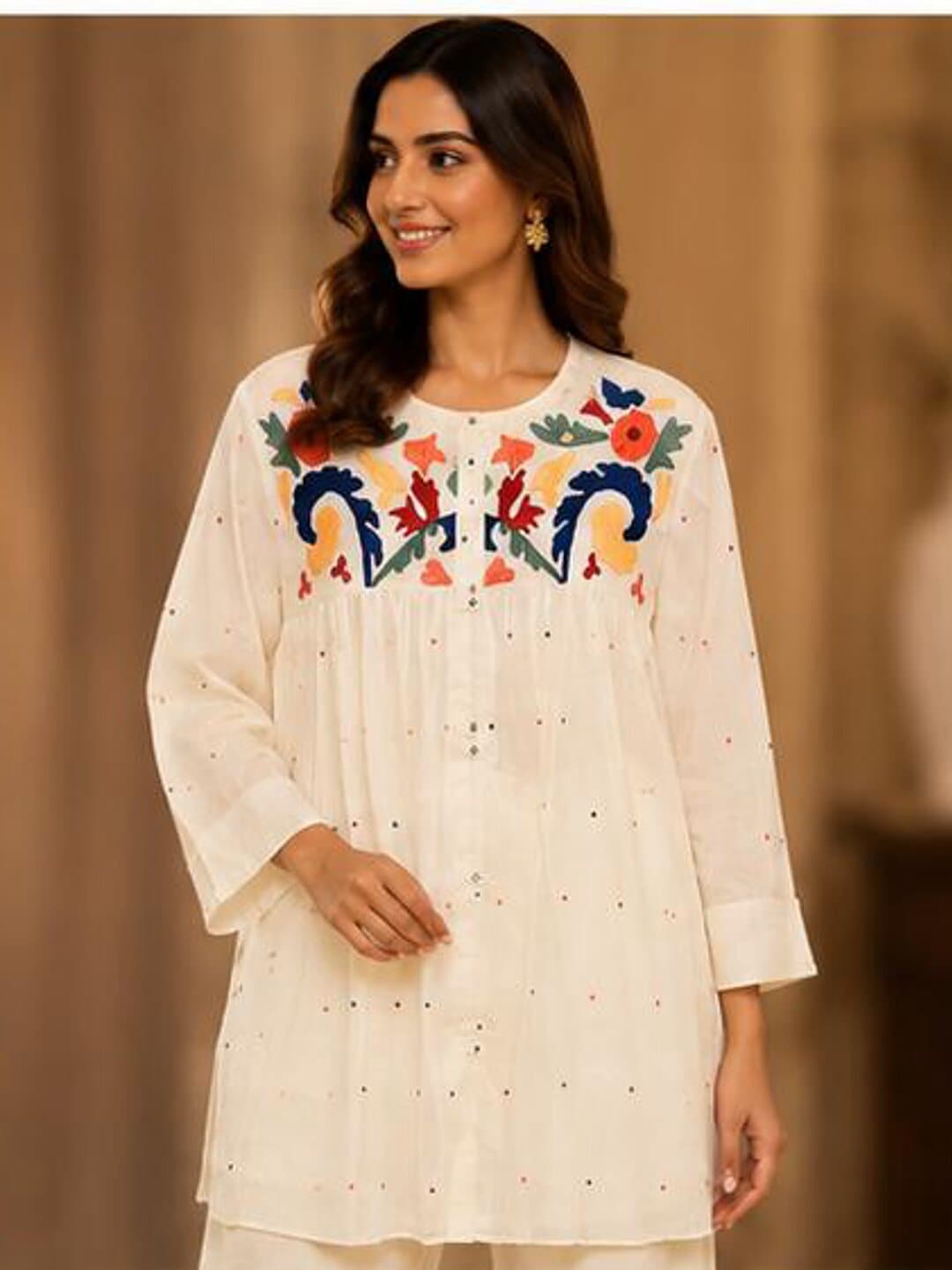 Ivory cotton kurta with a bold band of blue, saffron and coral flowers embroidered across the yoke